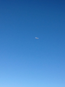 A lone plane slicing through the cloudless blue sky of summer.